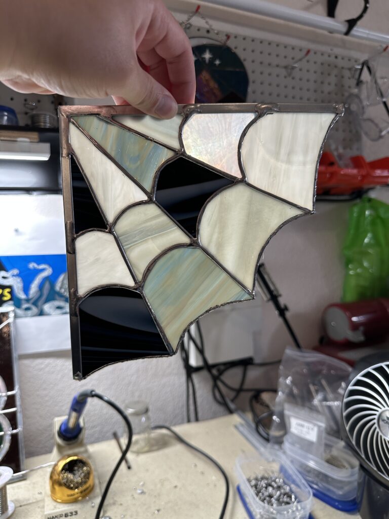 A 90 degree web with various shades of white, black, and gray pieces forming a web.