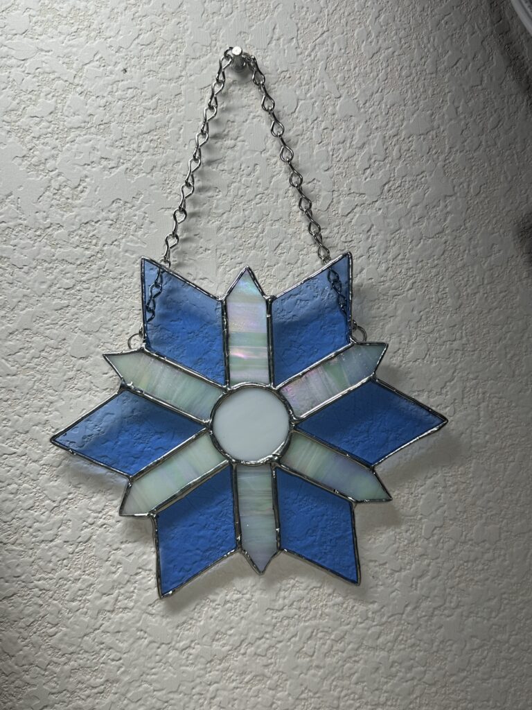 6 iridized white spokes with light blue diamonds in between.