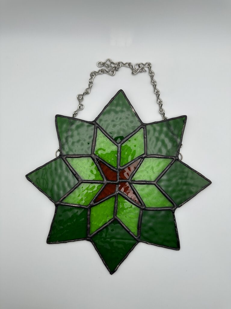 8 pointed green star with lighter green diamonds and 4 brown diamonds going into the center.