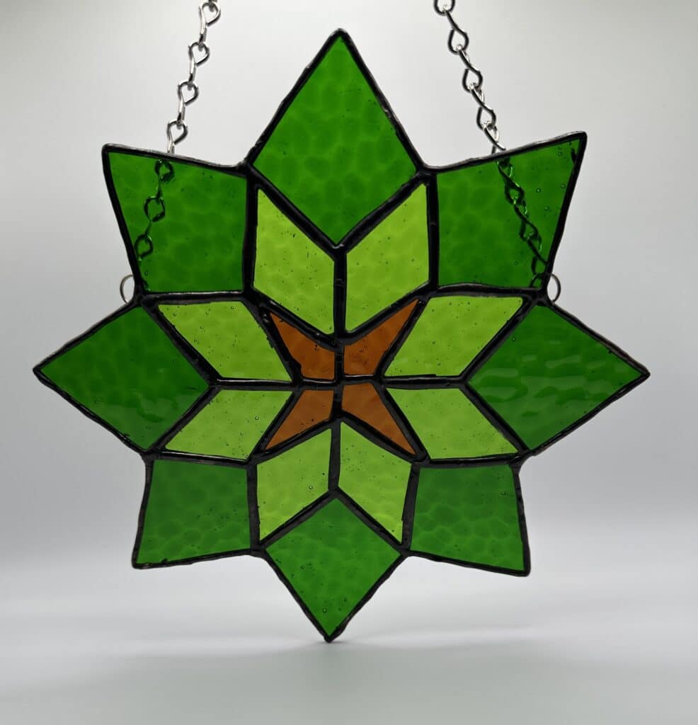 8 pointed green star with lighter green diamonds and 4 brown diamonds going into the center.