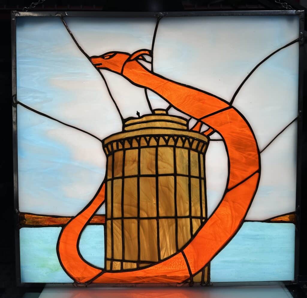 Orange and yellow dragon wrapped around a tower overlooking a sea.