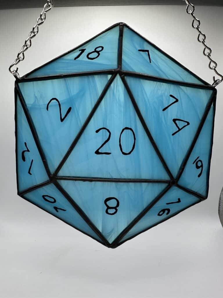 Streaky light blue D20 showing the 20 side up.