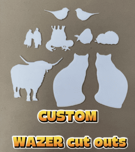 Intricately cut out white glass laid out on brown paper.